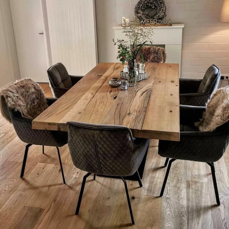 Gemütlicher Landhausstil mit heller Altholztischplatte, dunkler Drehstühlen und warmen Fellen