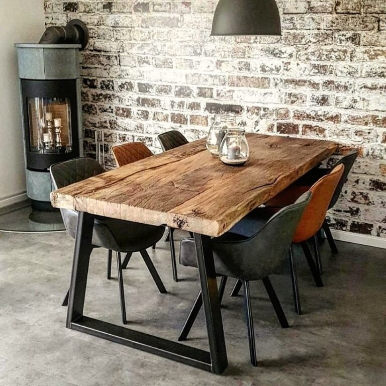 moderner Loftstil mit rustikalem Altholztisch vor gekalkter Steinwand und Holzofen mit sechs modernen Stühlen
