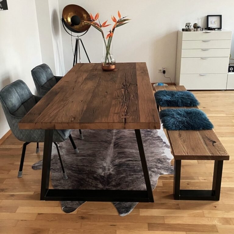 Altholztisch im maritinem Stil, mit dunkel geölter Holzbank, blauen Akzenten und Blumendeko