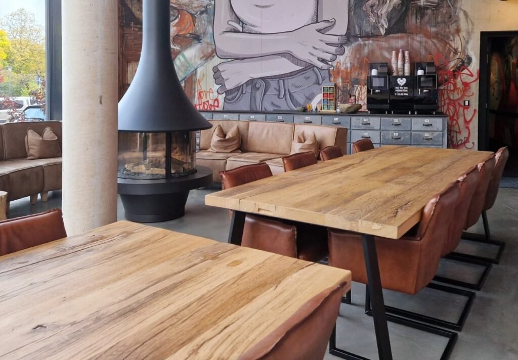 Tisch aus Altholz im Urban Art Hotel – starker Materialmix mit urbanem Flair.
