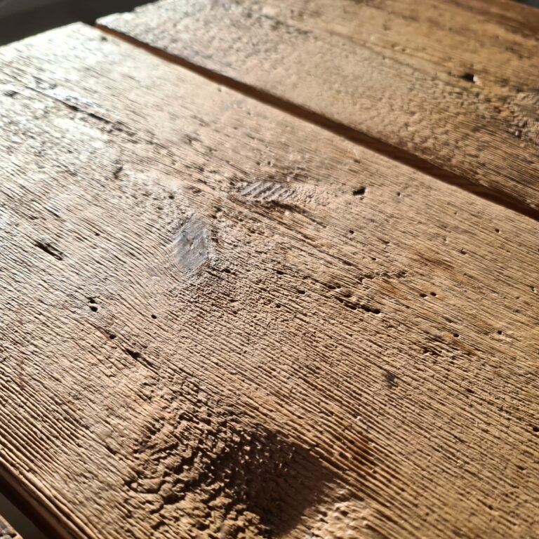 Nahaufnahme einer Tischplatte aus echtem Altholz – Fichte und Tanne mit kräftiger Struktur.