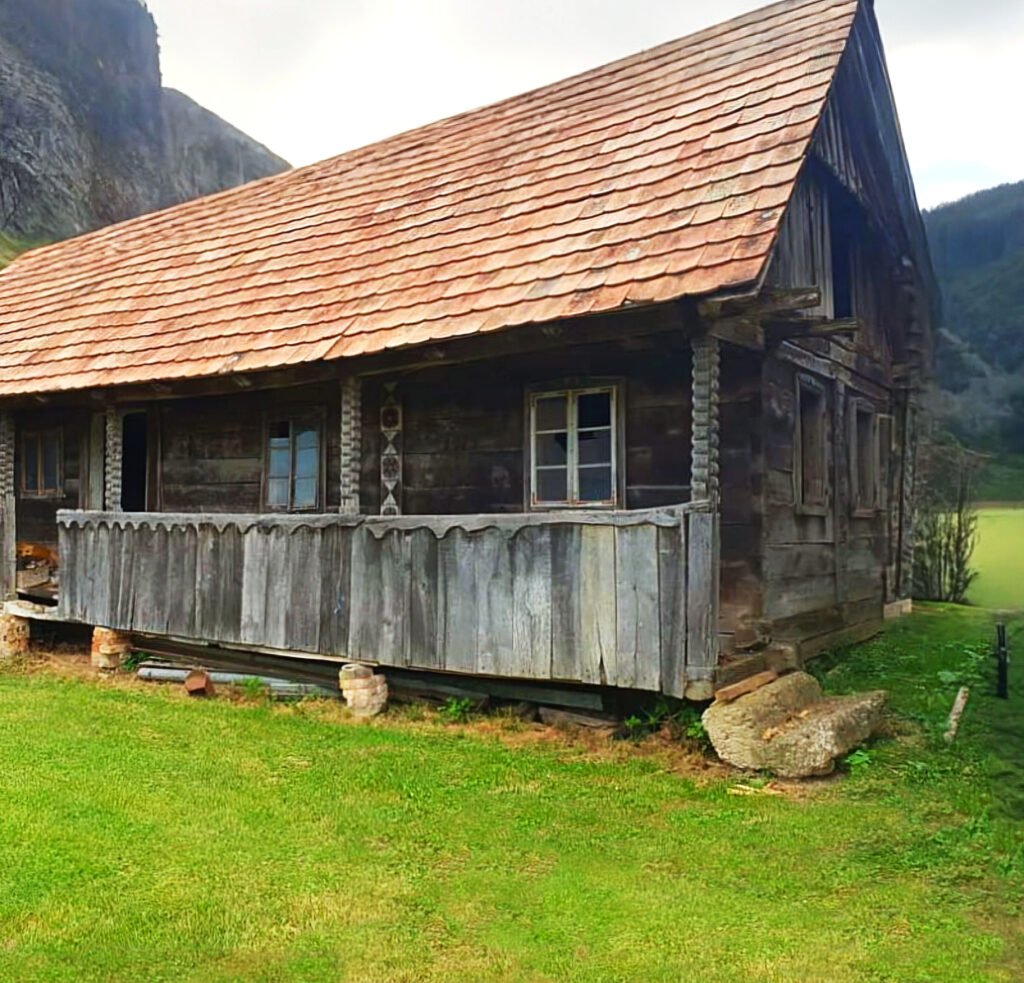 Altes Bauernhaus mit Vintage Holz Fassade und Ziegeldach in ländlicher Umgebung.