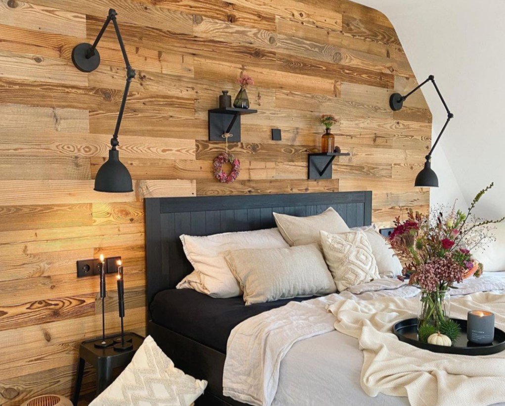 Schlafzimmer mit Wandverkleidung aus Vintage Holz hinter dem Bett