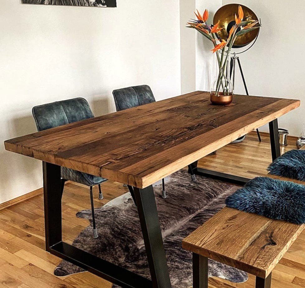 Massiver Esstisch aus Altholz mit lebendiger Maserung und natürlicher Oberfläche im modernen Wohnraum